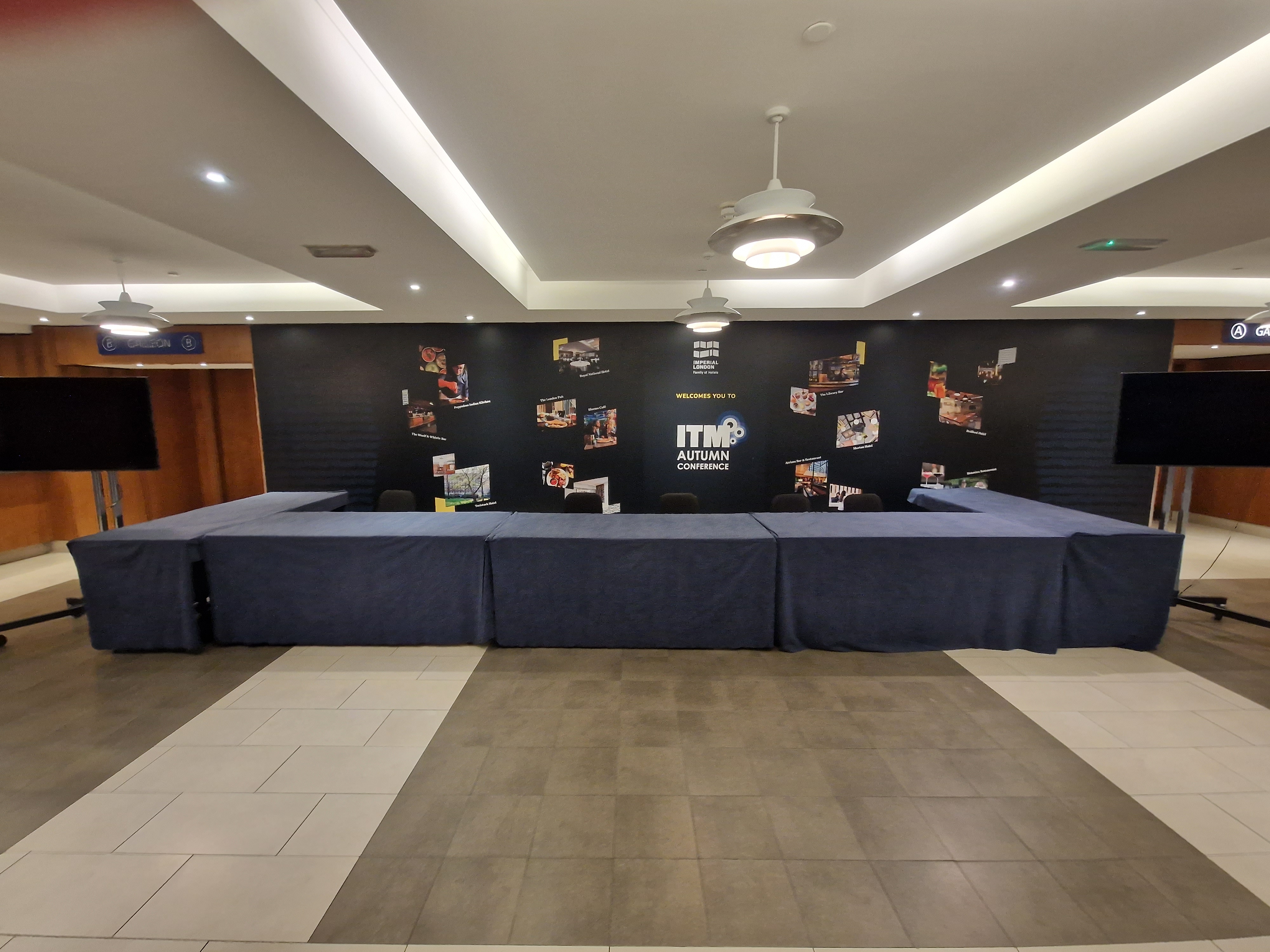 Galleon Total event space with draped table and screens for a professional conference.