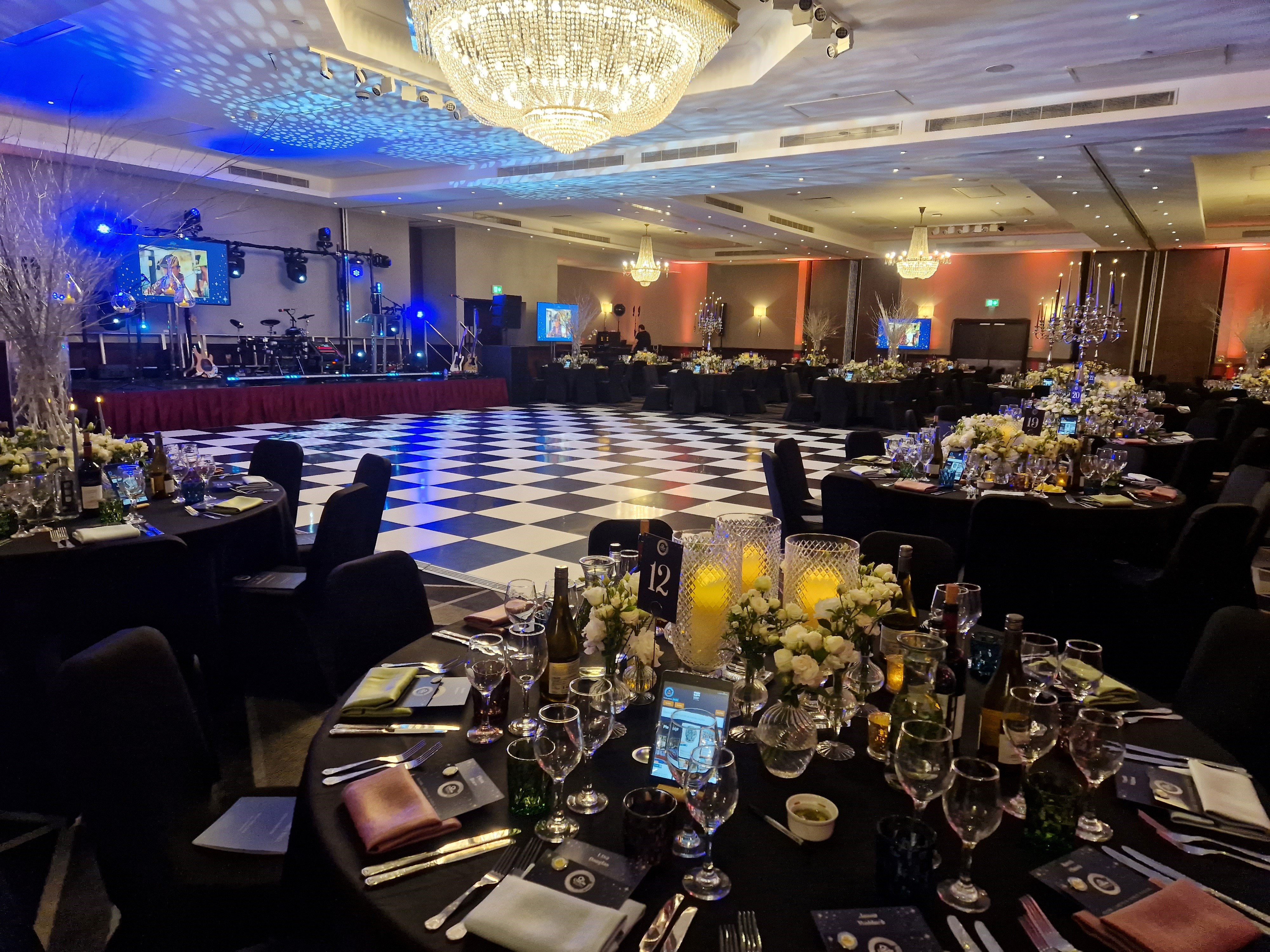 Elegant banquet hall with checkered dance floor for gala or corporate event.