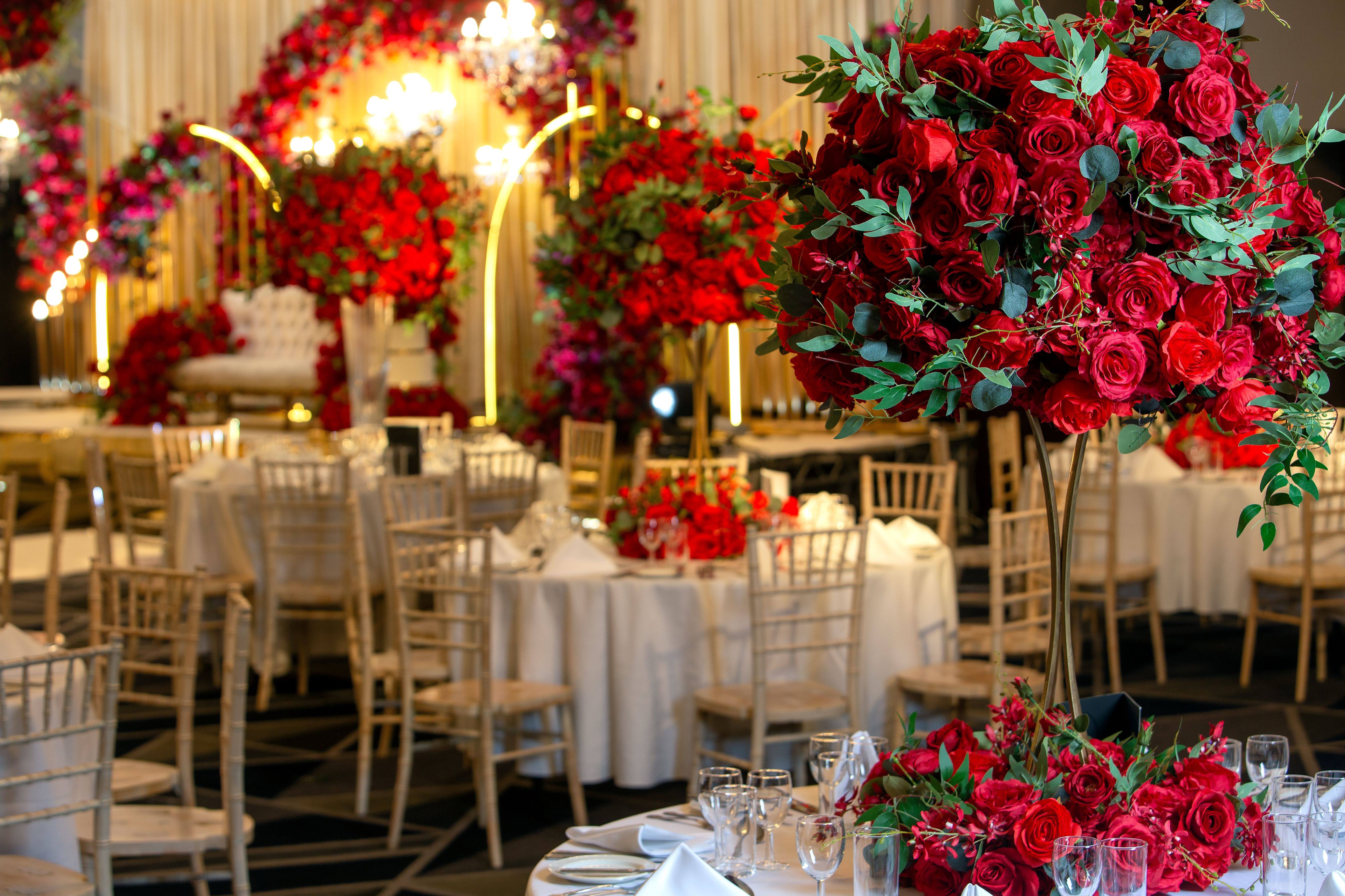 Elegant event space with round tables and vibrant floral centerpieces for weddings.