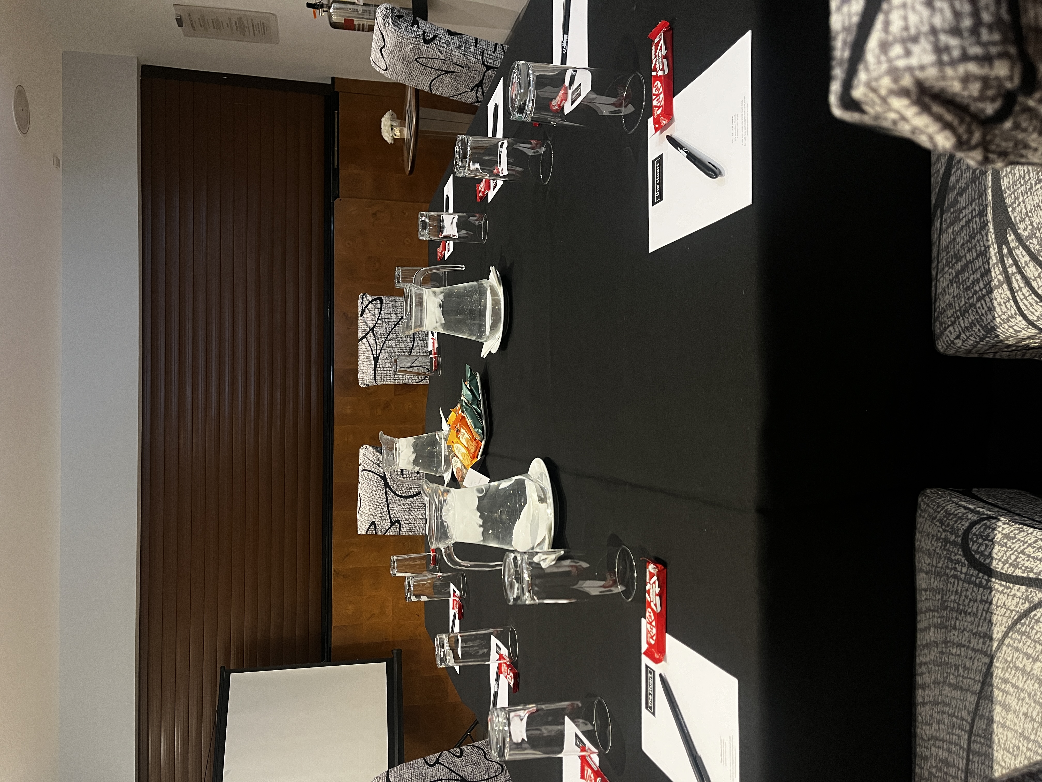 Meeting room at The Stuart Hotel with central table, water pitchers, and notepads for events.