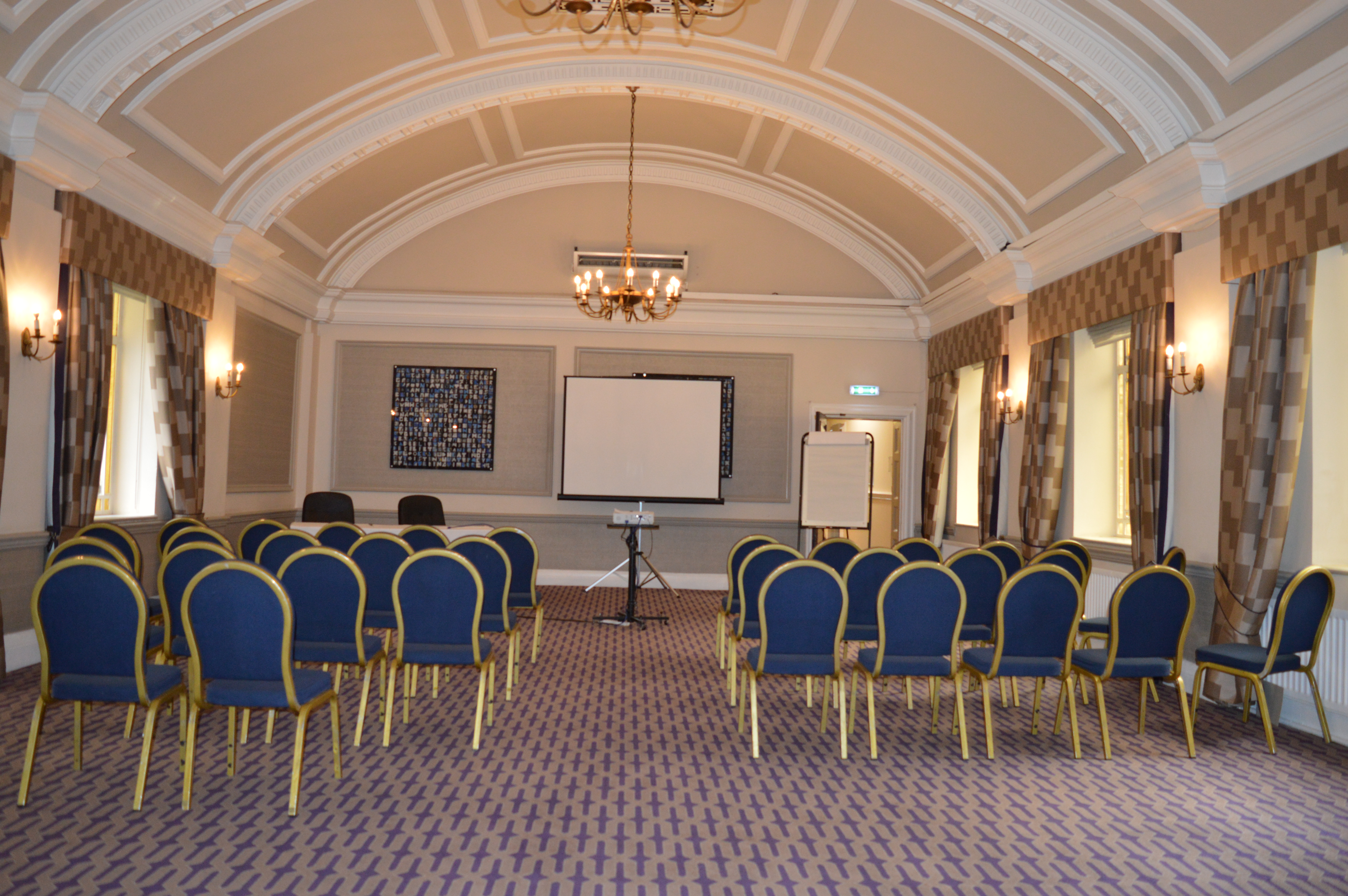 Ampthill Suite meeting room with blue chairs, ideal for workshops and presentations.