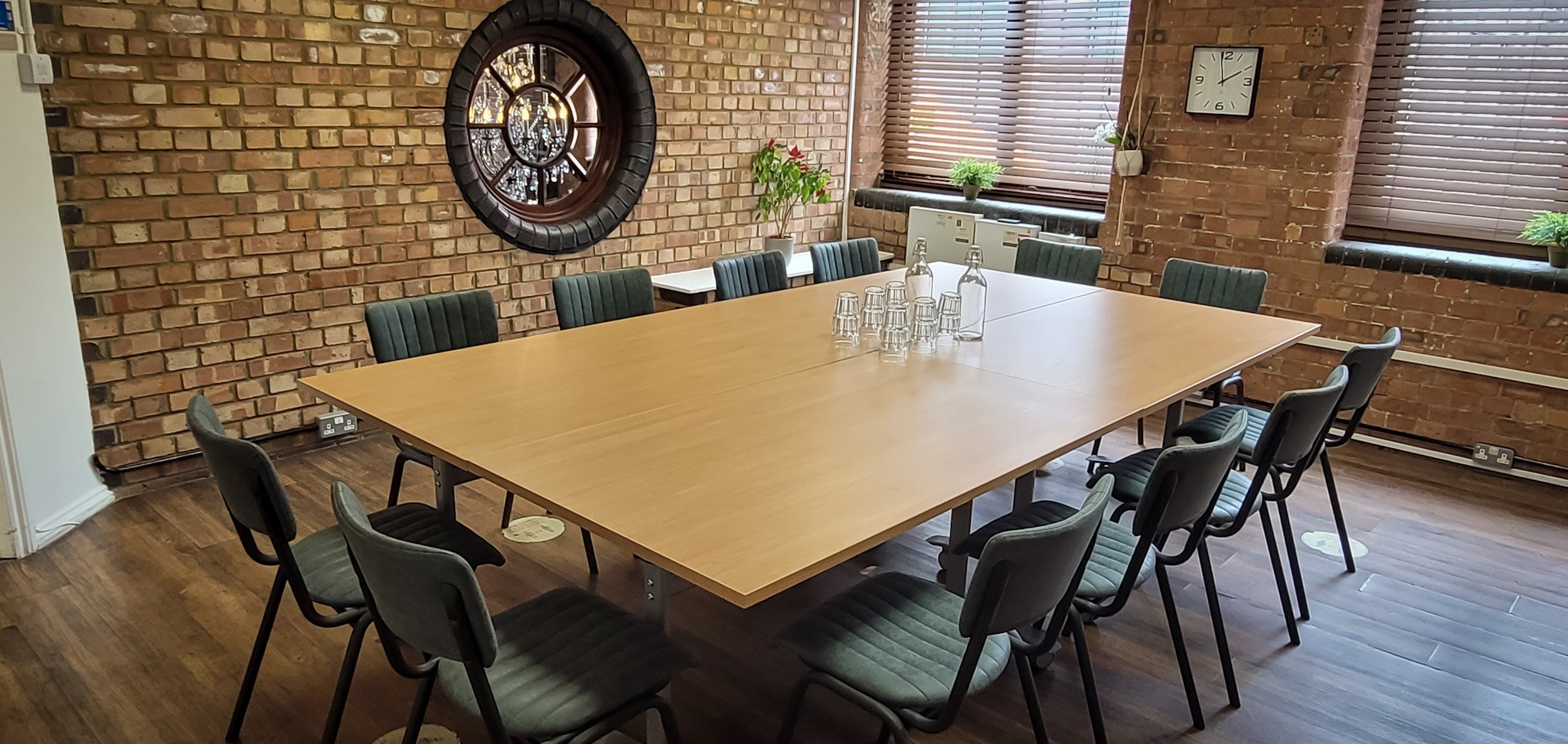 Green Room at Remark! Events: spacious meeting room with brick walls for collaborative sessions.