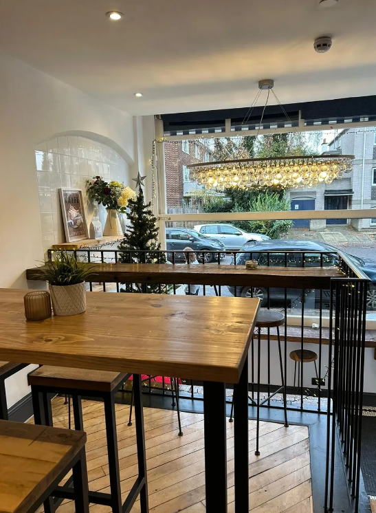 Cozy cafe meeting space with wooden table, ideal for gatherings and brainstorming events.