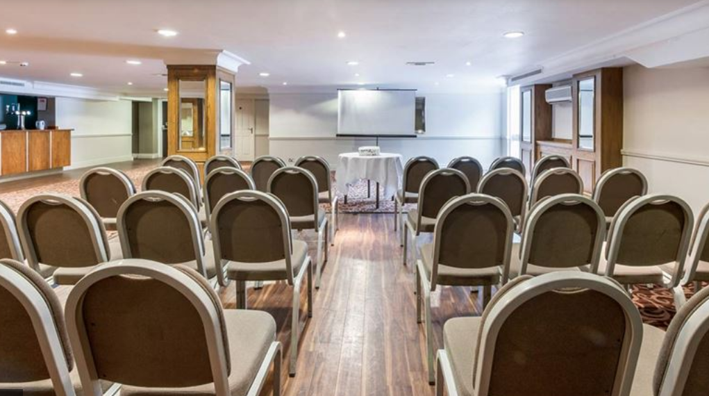 Conference room with chairs and screen at Best Western Pinewood for corporate meetings.