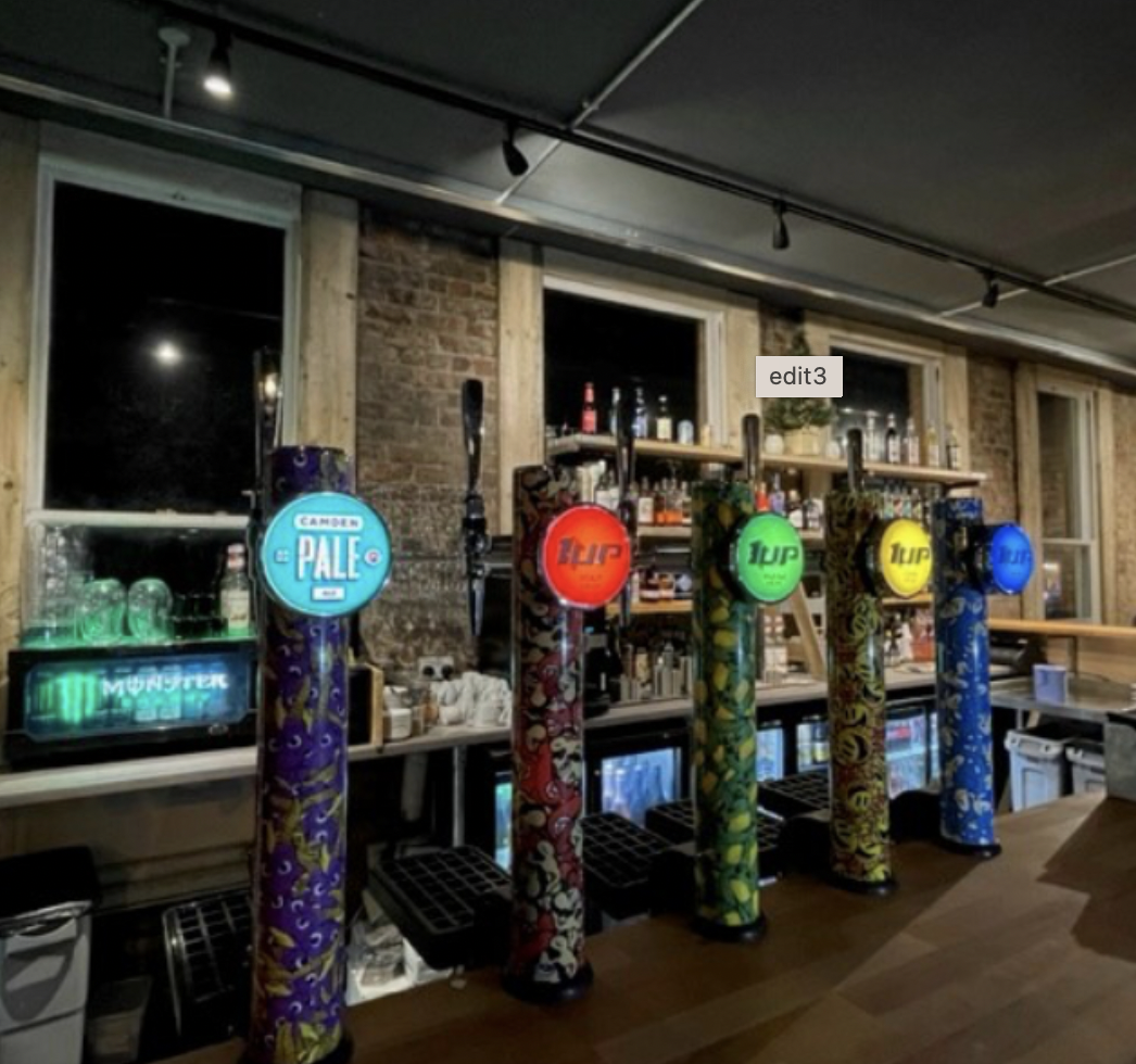 Vibrant bar setup with colorful beer taps for social gatherings at 1 Up Didsbury.