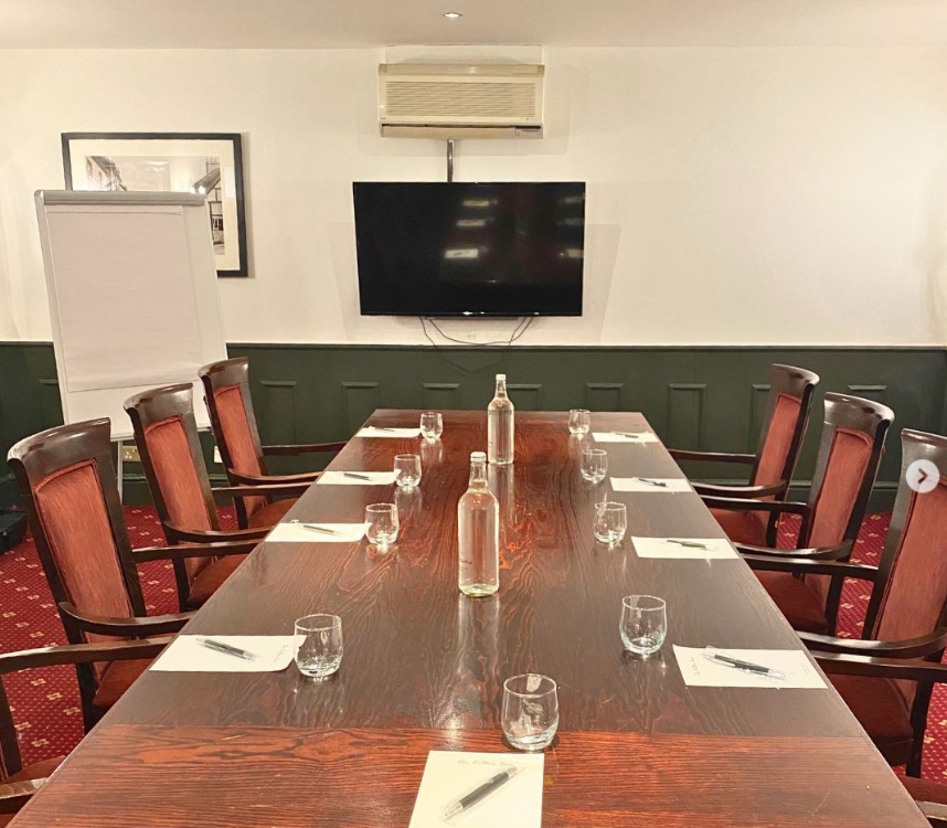 Meeting room at The Hub, featuring a long wooden table for professional gatherings.