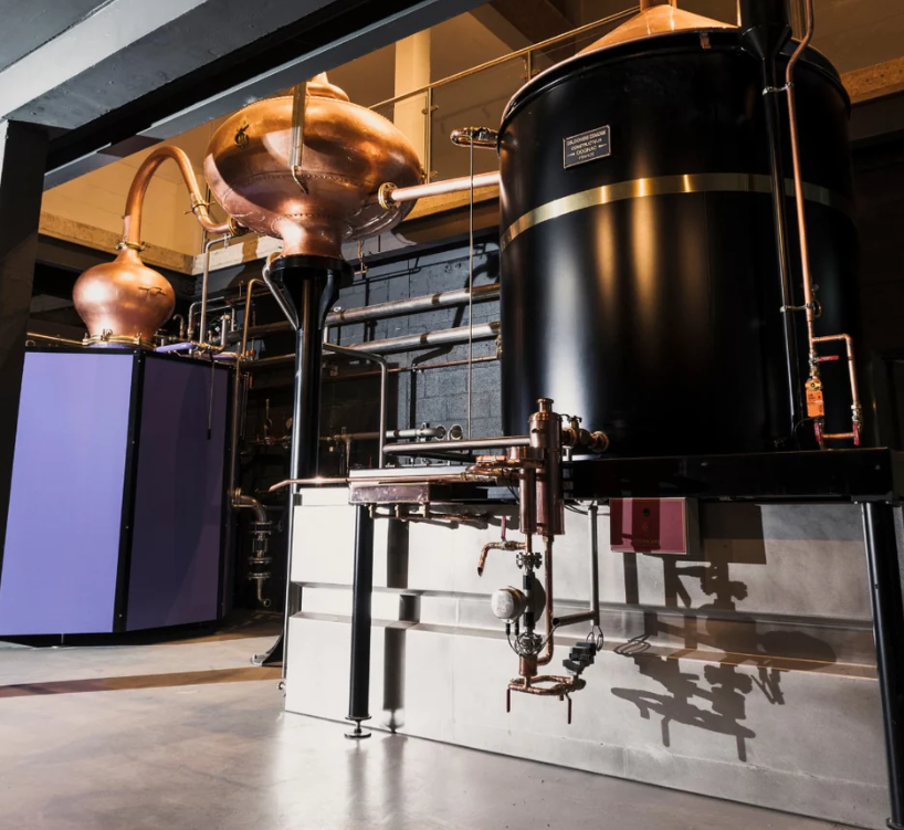 Modern distillery bar with copper equipment for corporate retreats and team-building events.