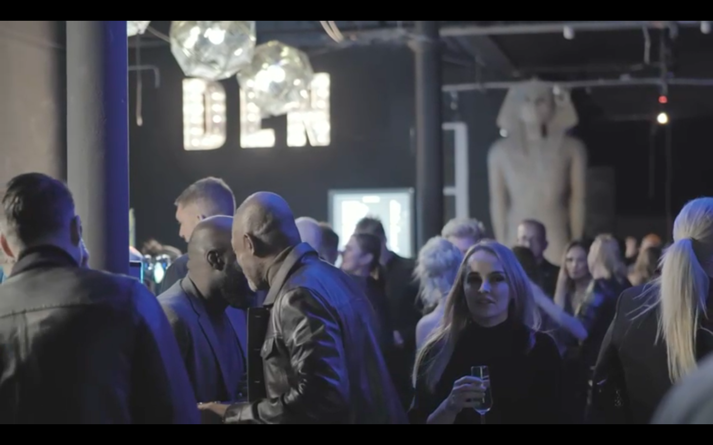 Vibrant networking event in The Den's stylish Main Room with modern decor.