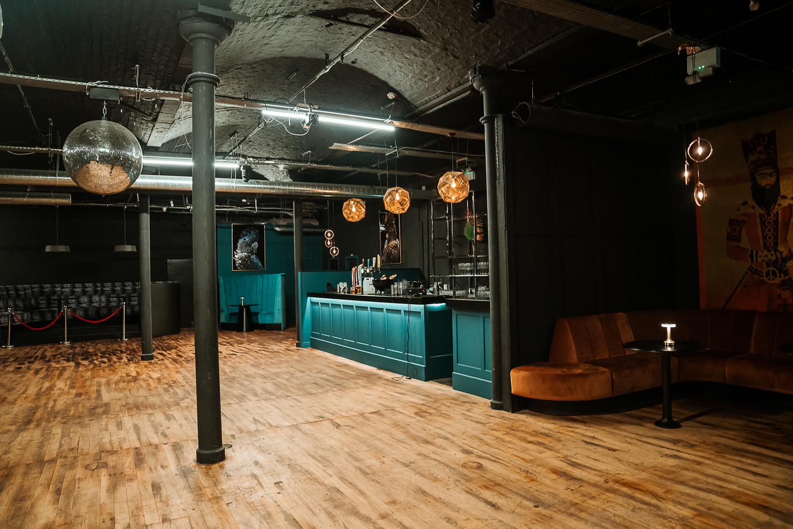 Versatile event space in The Den with stylish bar and stage for gatherings or meetings.