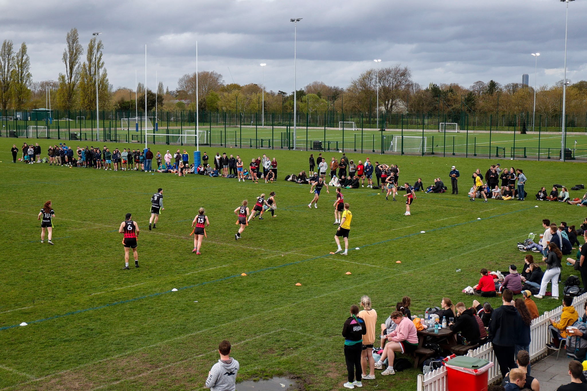Outdoor rugby match at King's House School with enthusiastic spectators and vibrant atmosphere.