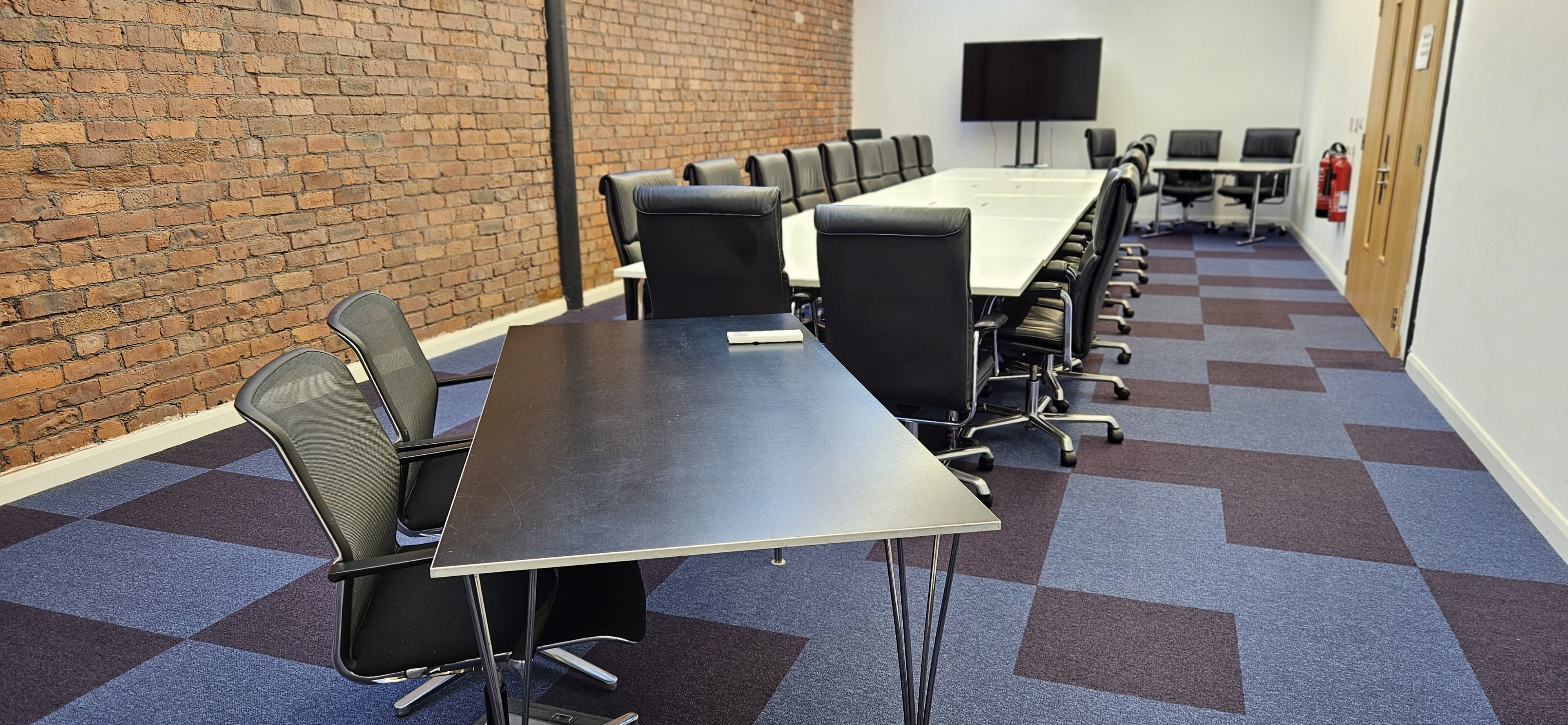 Modern meeting room at Ram Mill, featuring a long table and ergonomic chairs for workshops.