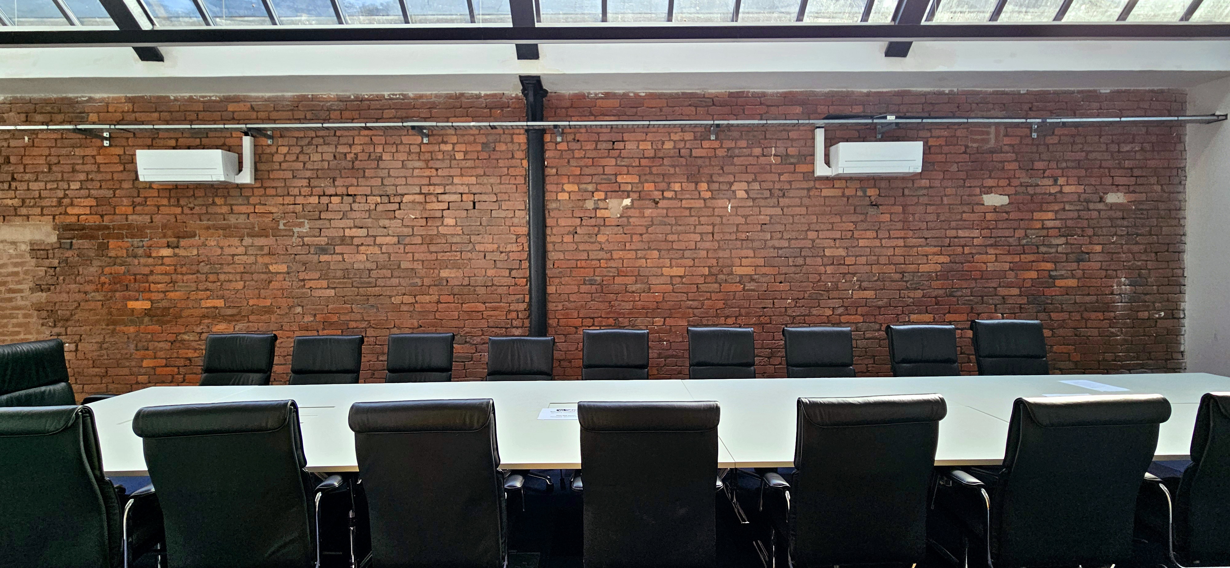Modern meeting room with sleek table, black chairs, ideal for collaboration and brainstorming.