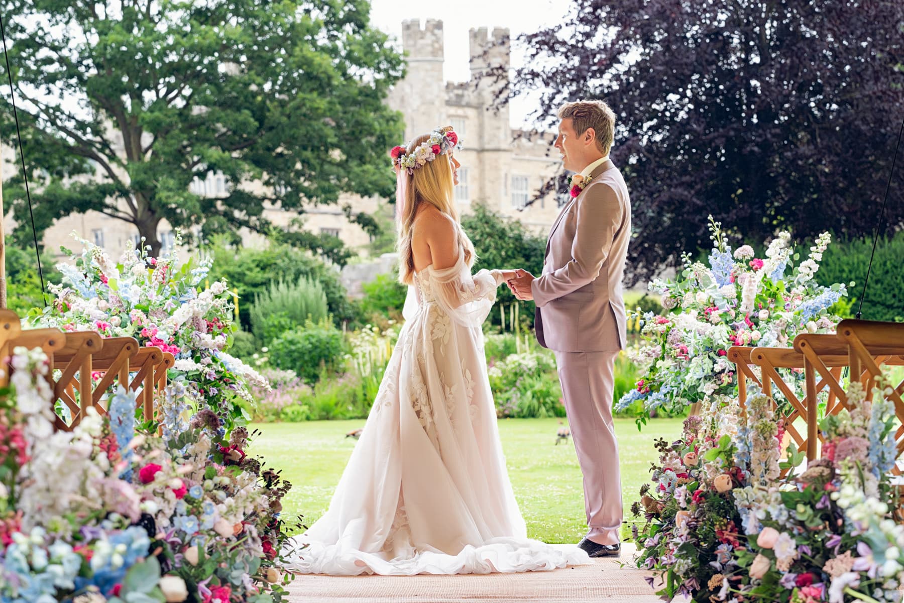 Luxury outdoor wedding ceremony at Leeds Castle with floral arches for premium venue events.