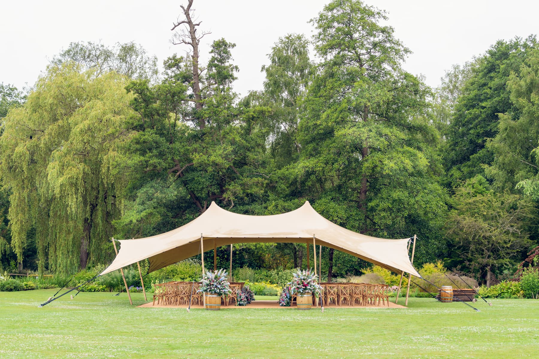 Elegant outdoor wedding marquee at Leeds Castle featuring neutral seating and natural greenery.