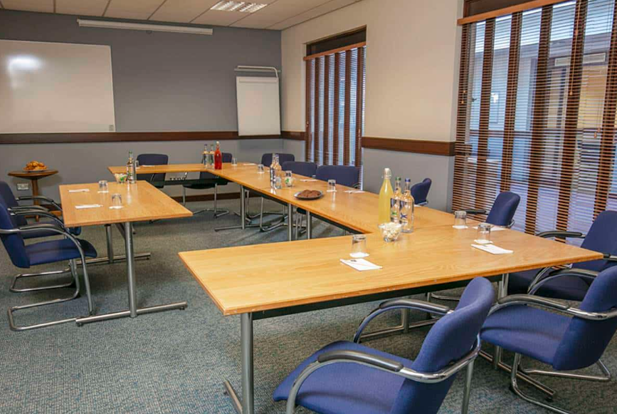 Meeting room at The Milestone Hotel, Peterborough, with natural light for professional gatherings.