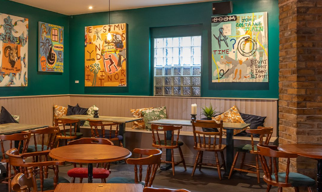 Cozy Pacific Tavern pub with vibrant artwork, perfect for intimate meetings and events.