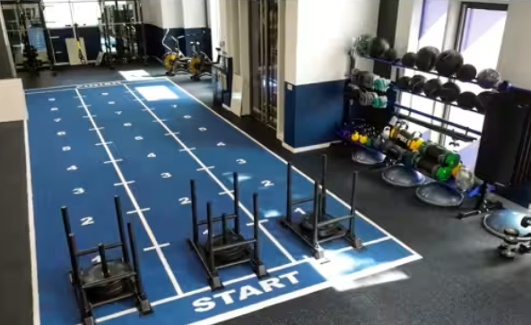 Modern fitness studio with blue sprint track for team-building and wellness events.