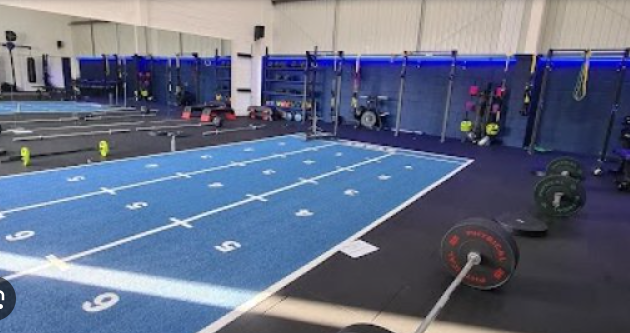 Modern fitness studio with blue track, ideal for wellness retreats and corporate challenges.
