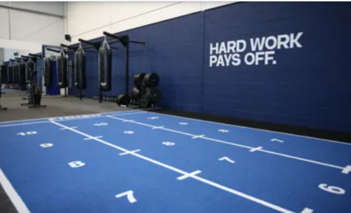Fitness studio with blue track and boxing bags for team-building and wellness events.