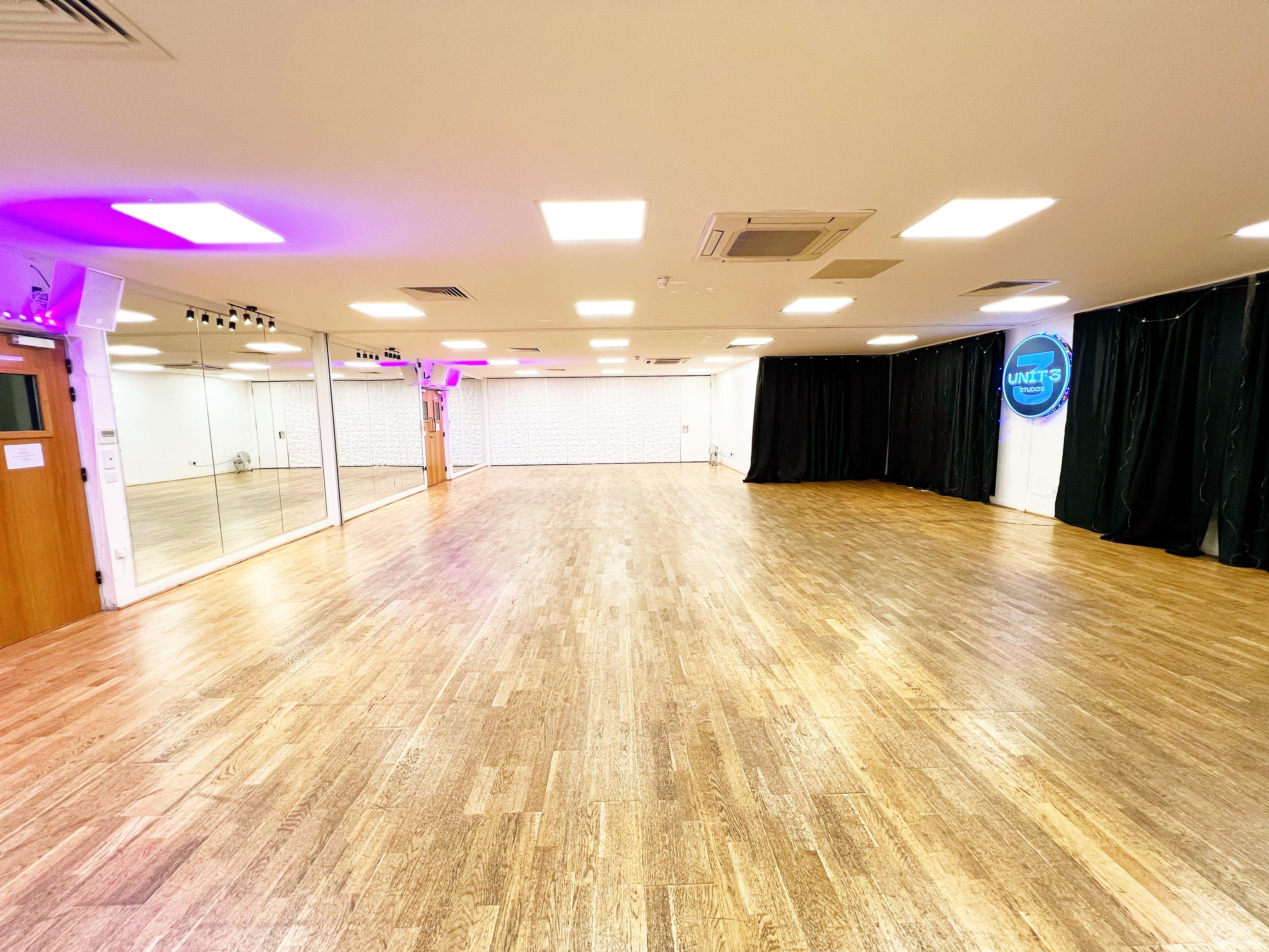 Versatile event space with polished wooden floor, ideal for meetings and workshops.