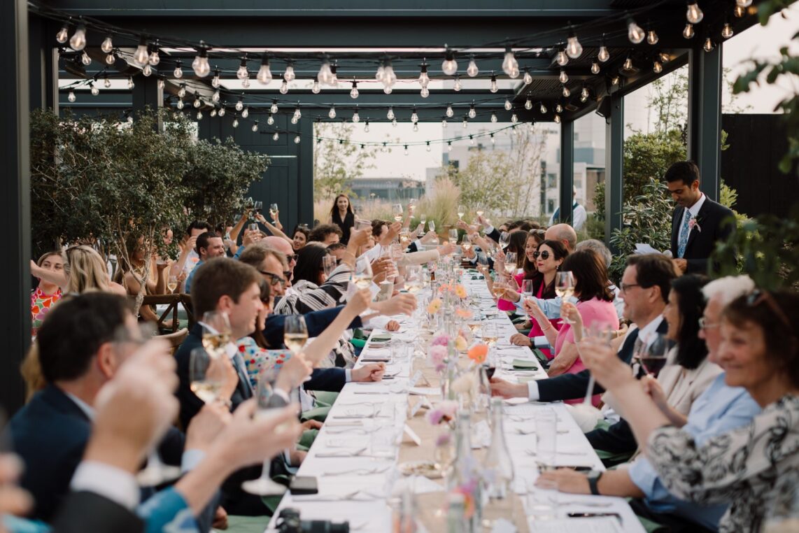 Outdoor event at The Pergola with elegant table setting and string lights.