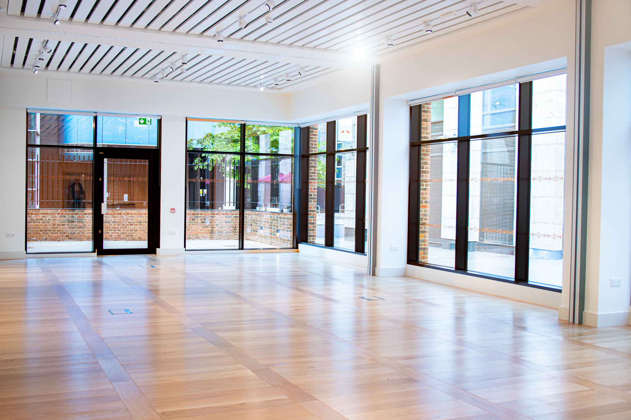Spacious event space with large windows in The Aldgate Centre, perfect for gatherings.