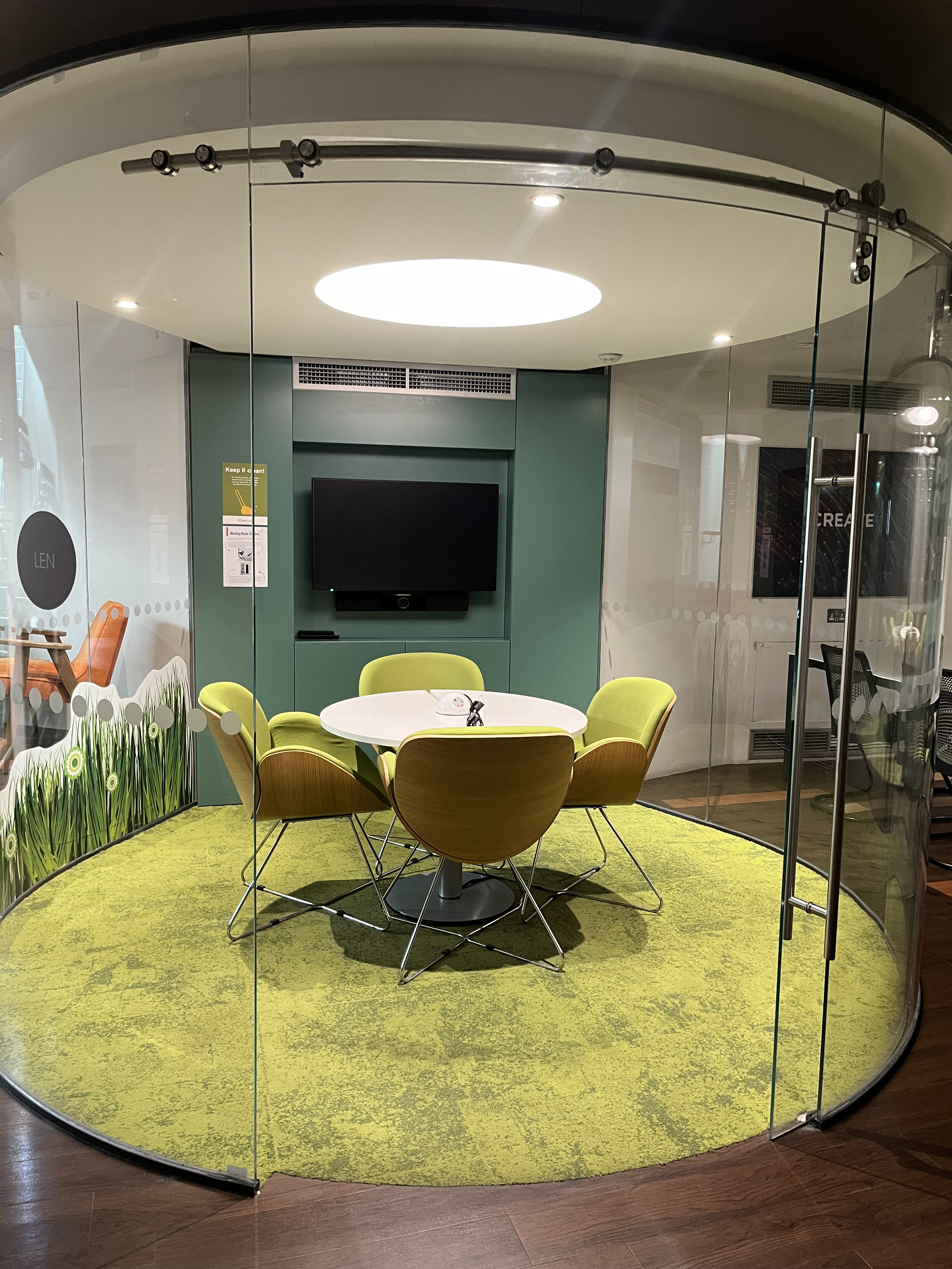 Modern meeting space with round table and vibrant seating at Pod Len, IDEALondon.
