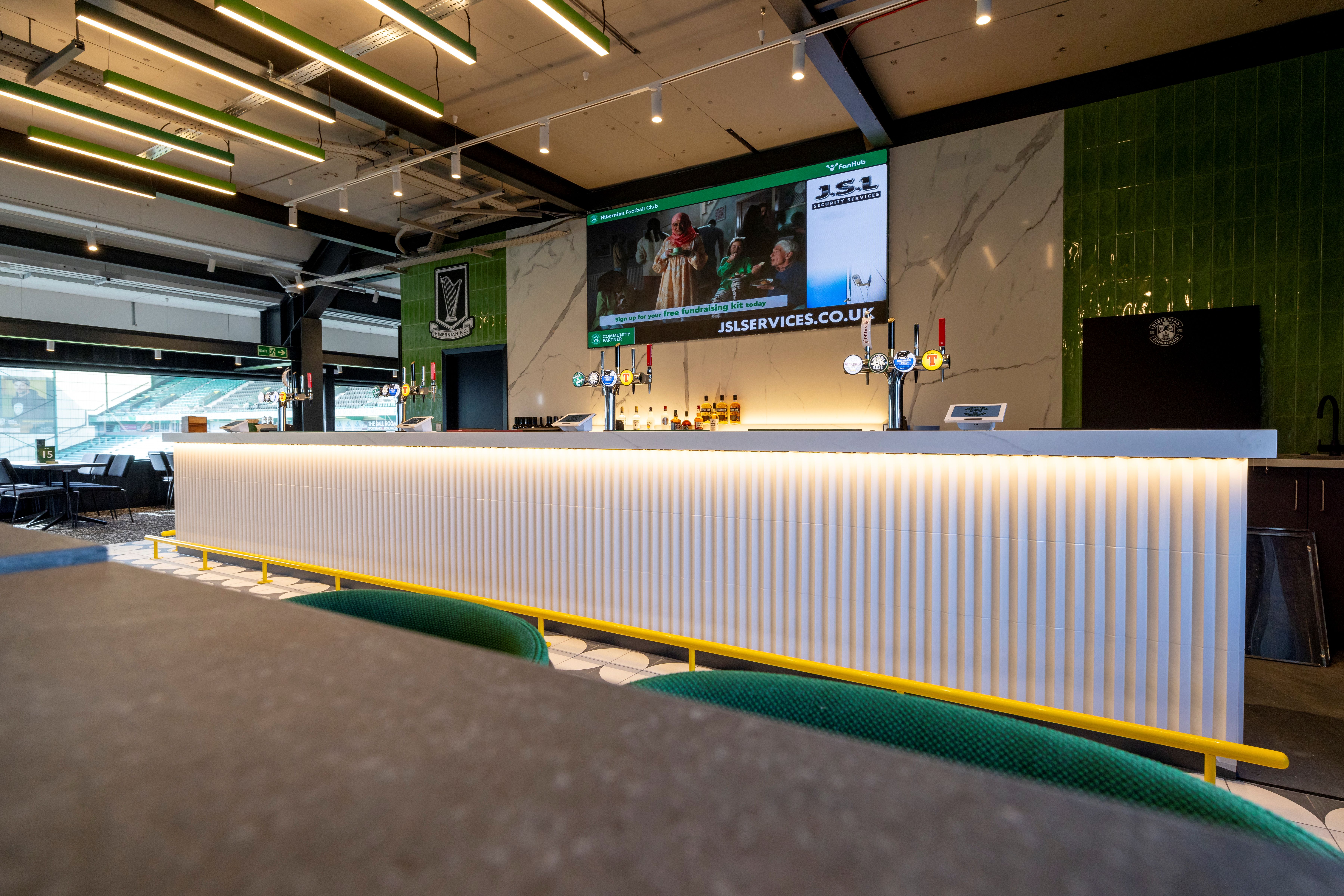Modern event bar at Hibernian FC with illuminated counter and large screen for presentations.