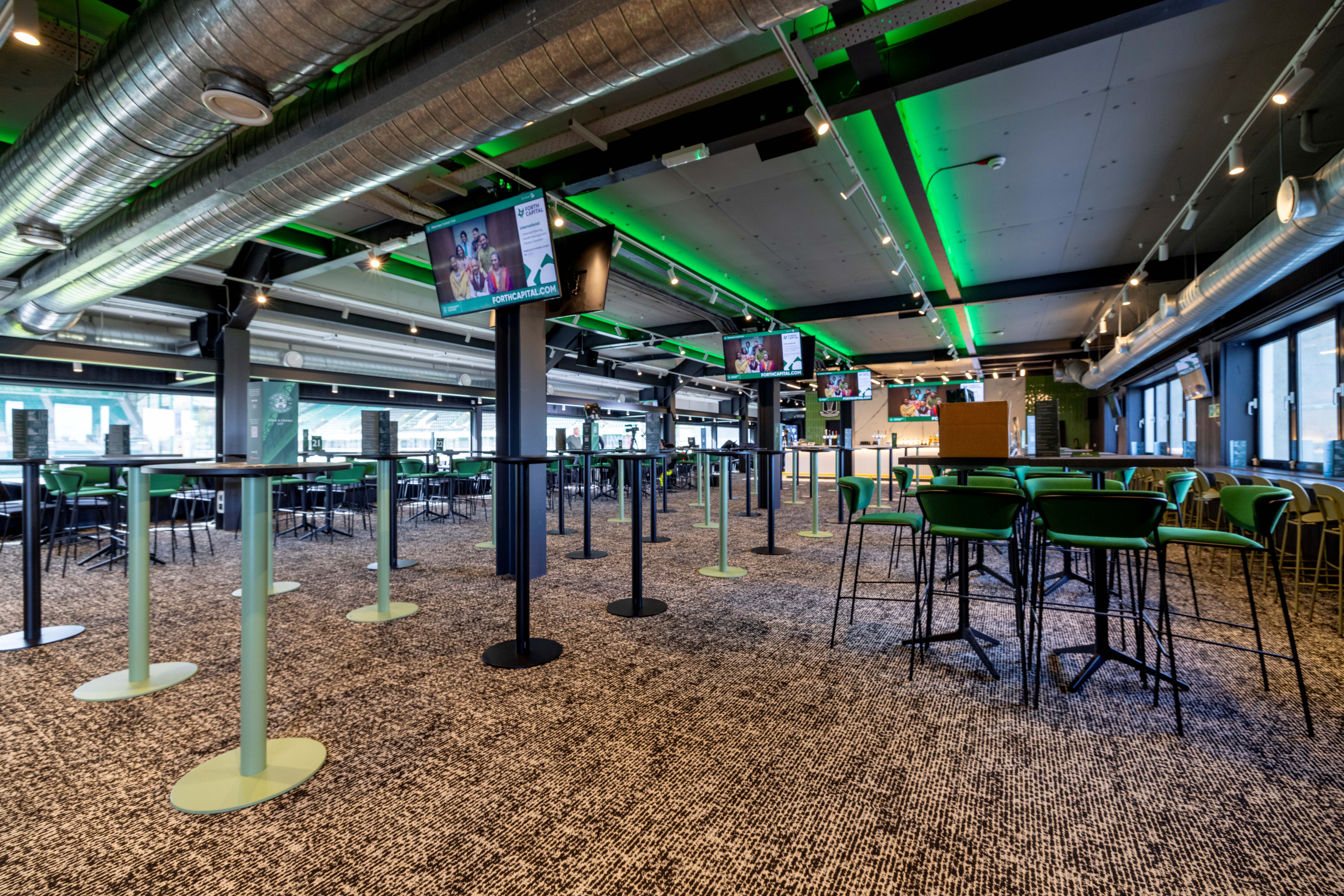 Modern event space at Hibernian FC with high-top tables for networking events.