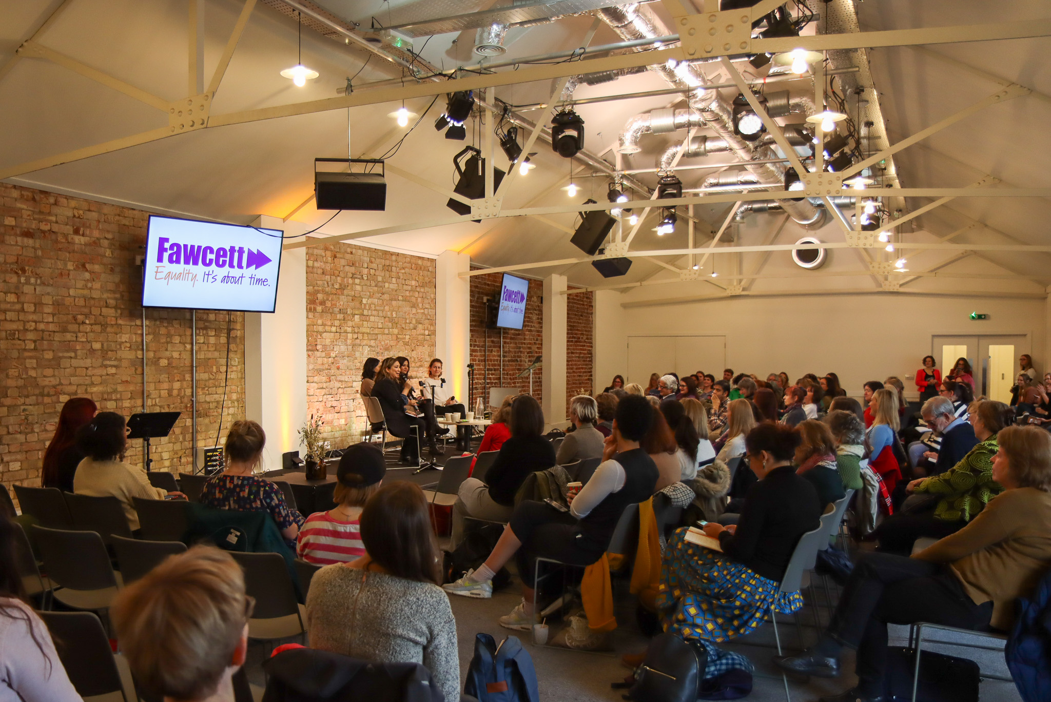 Panel discussion at Away Days conference in modern venue with diverse speakers.