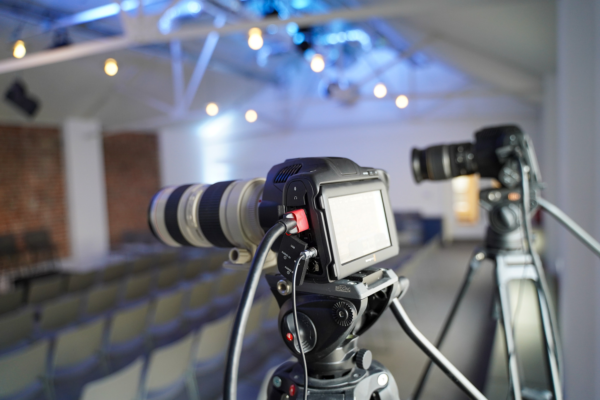 Hybrid event setup with cameras for live streaming and music in King's House.