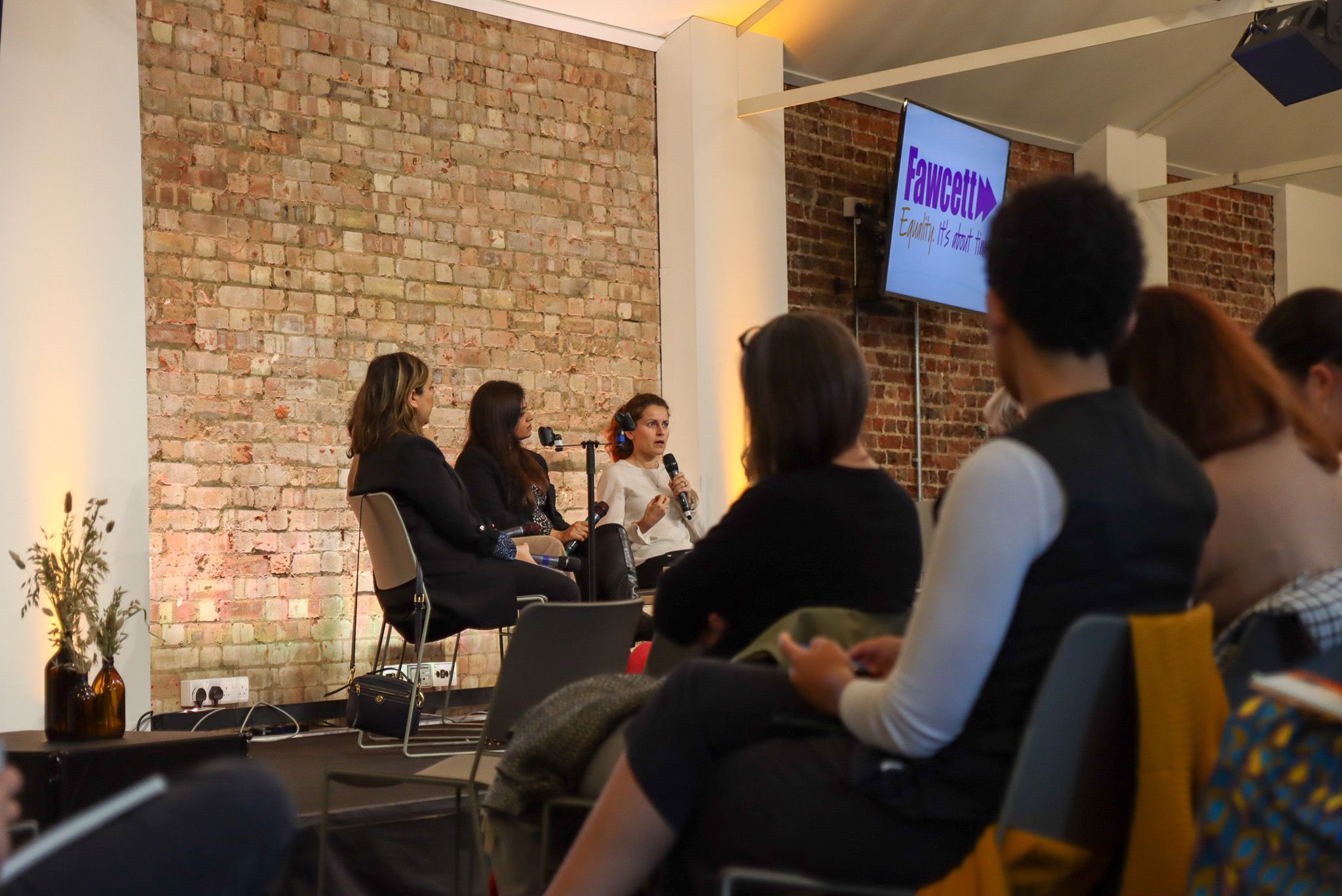 Panel discussion in modern venue with engaged audience at King's House workshop.