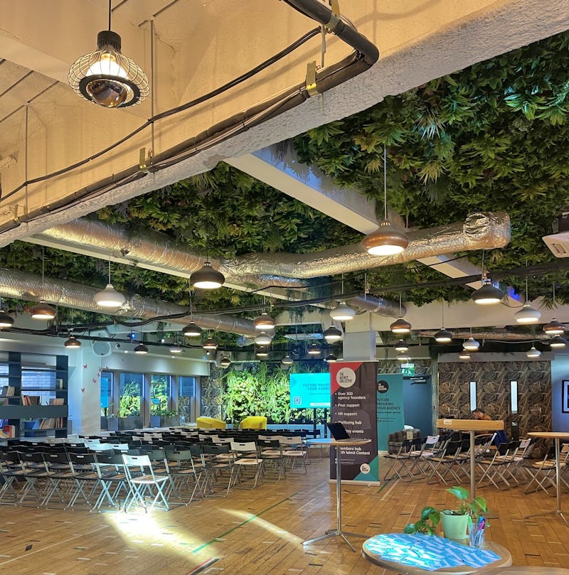 Modern event space with green ceiling, perfect for creative workshops and presentations.