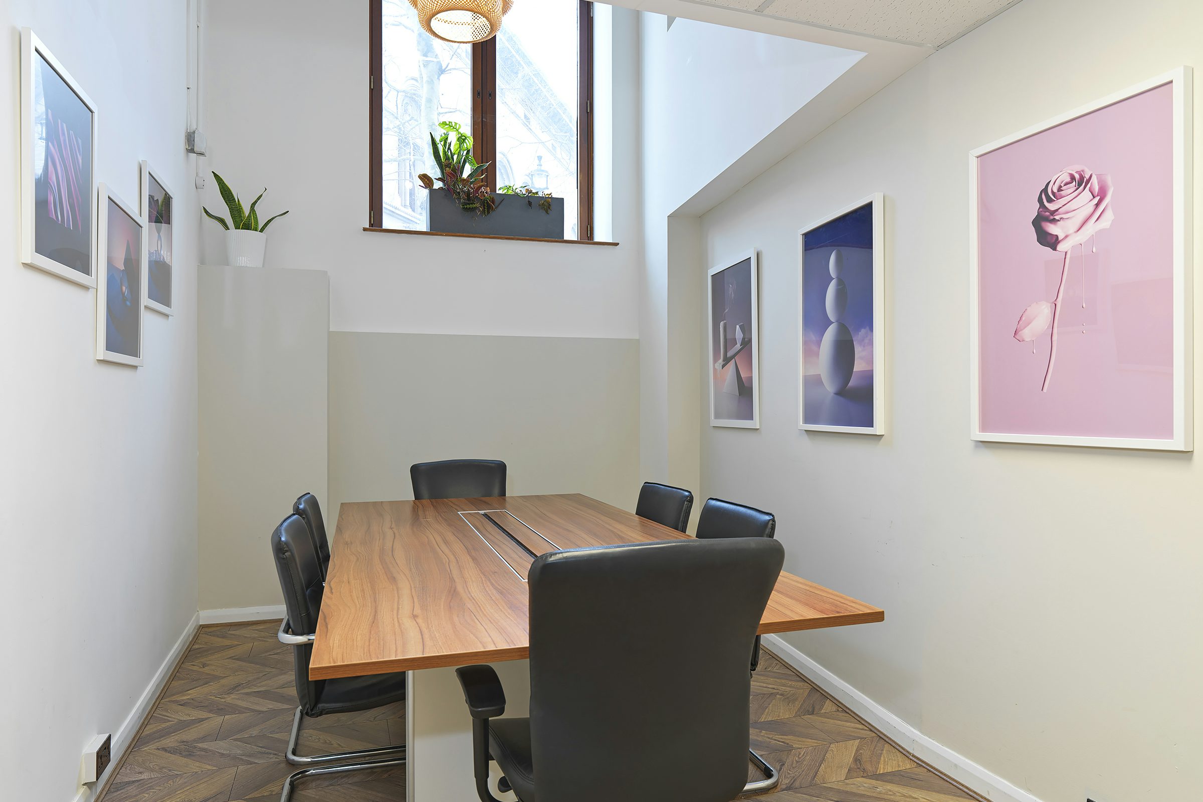 Modern meeting room at The Hub on the Square, featuring a sleek wooden table for collaboration.