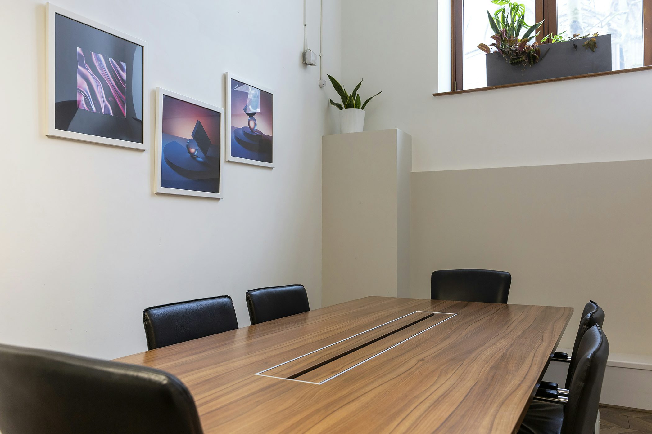 Modern meeting room at The Hub on the Square, featuring a sleek wooden table and tech.