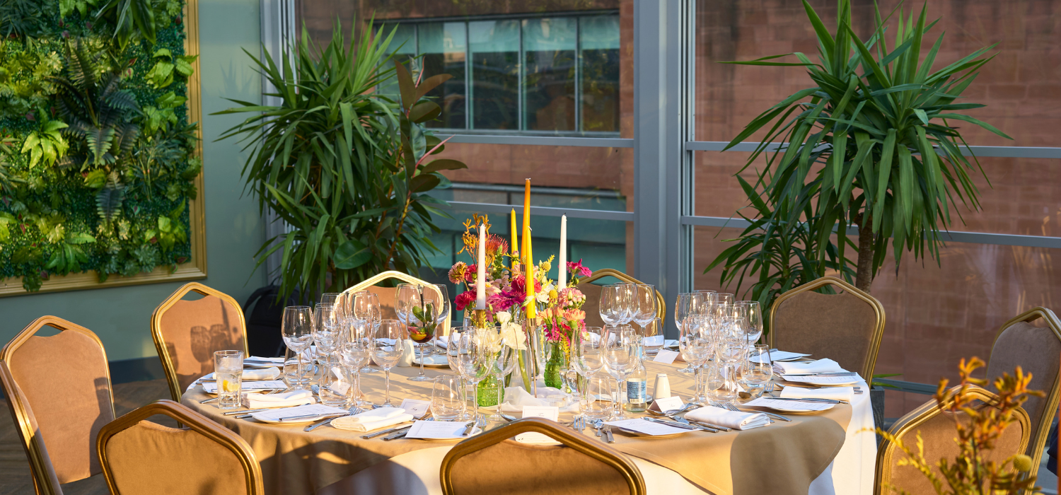 Elegant dining table with fresh flowers in Manchester Hall for high-end events.