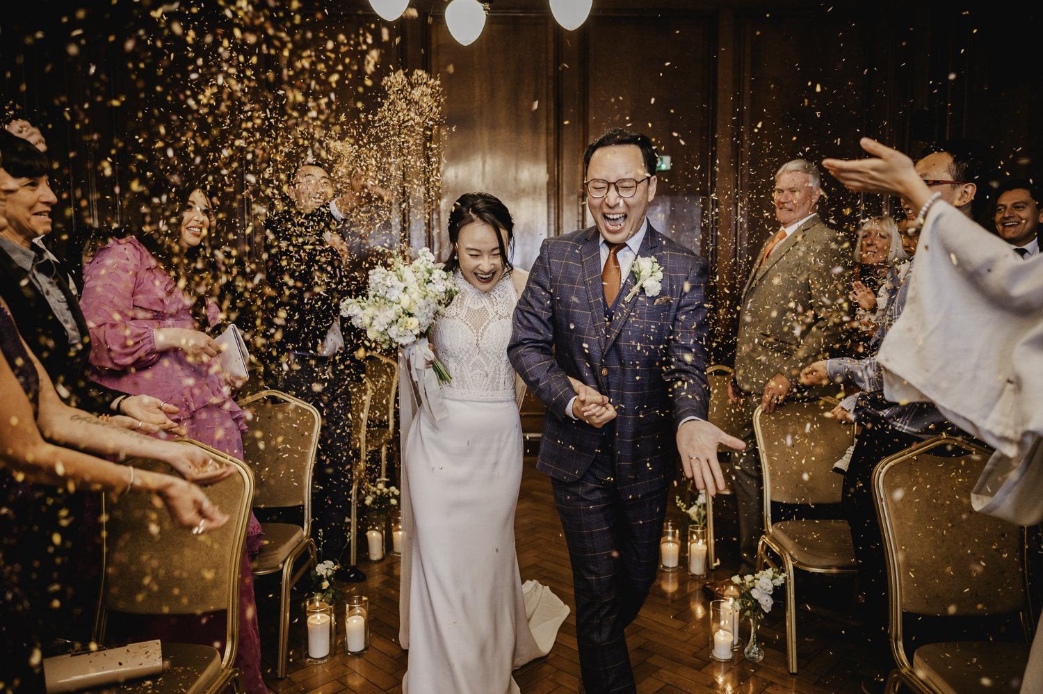Joyful wedding celebration in The Drawing Room, Manchester Hall with confetti shower.