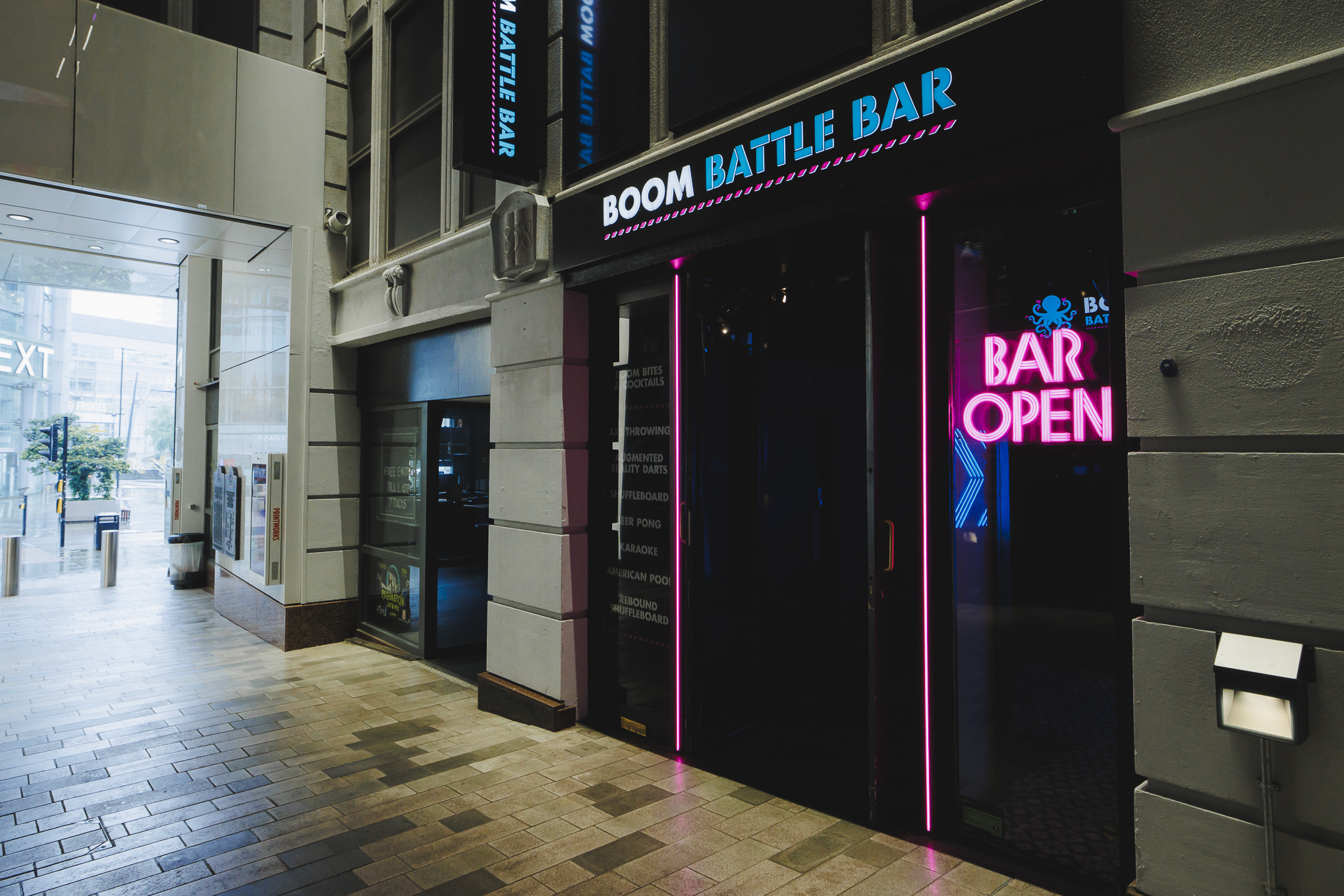 "Boom Battle Bar Manchester entrance with neon sign for networking events and team-building."