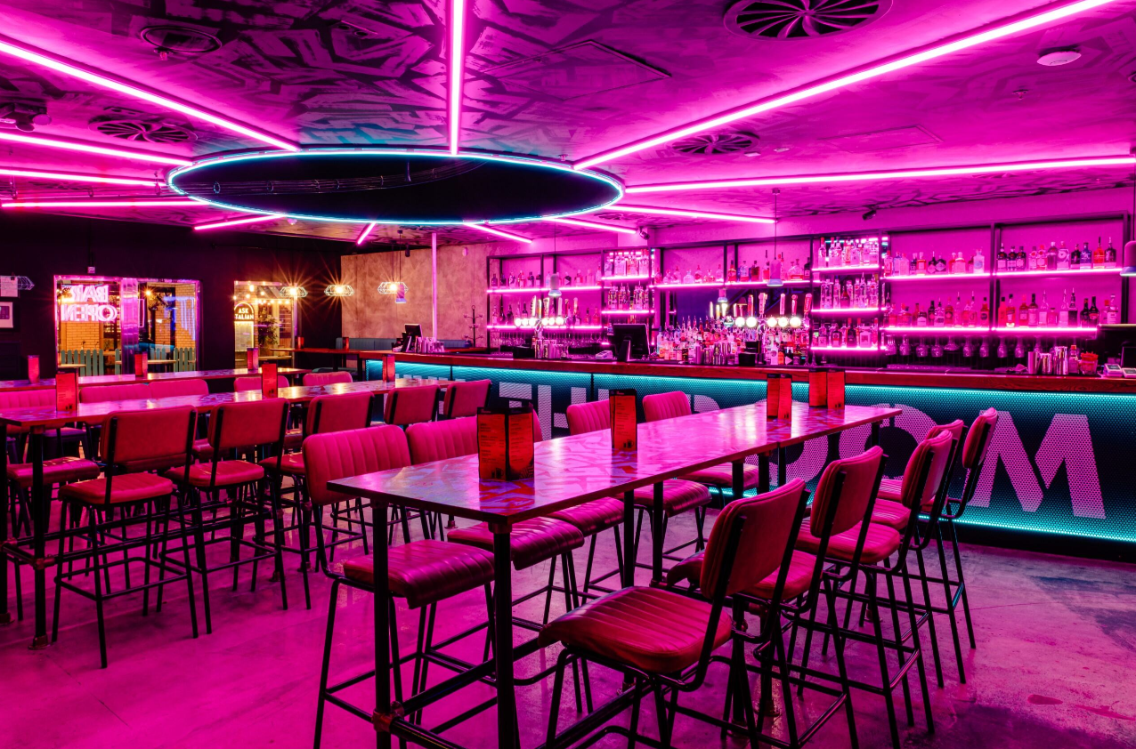 Exclusive private hire event space at Boom Battle Bar O2 with pink neon lighting.