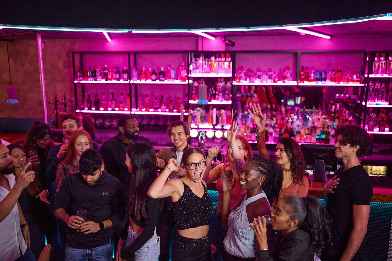 Vibrant private hire event at Boom Battle Bar O2 with colorful lighting and lively atmosphere.