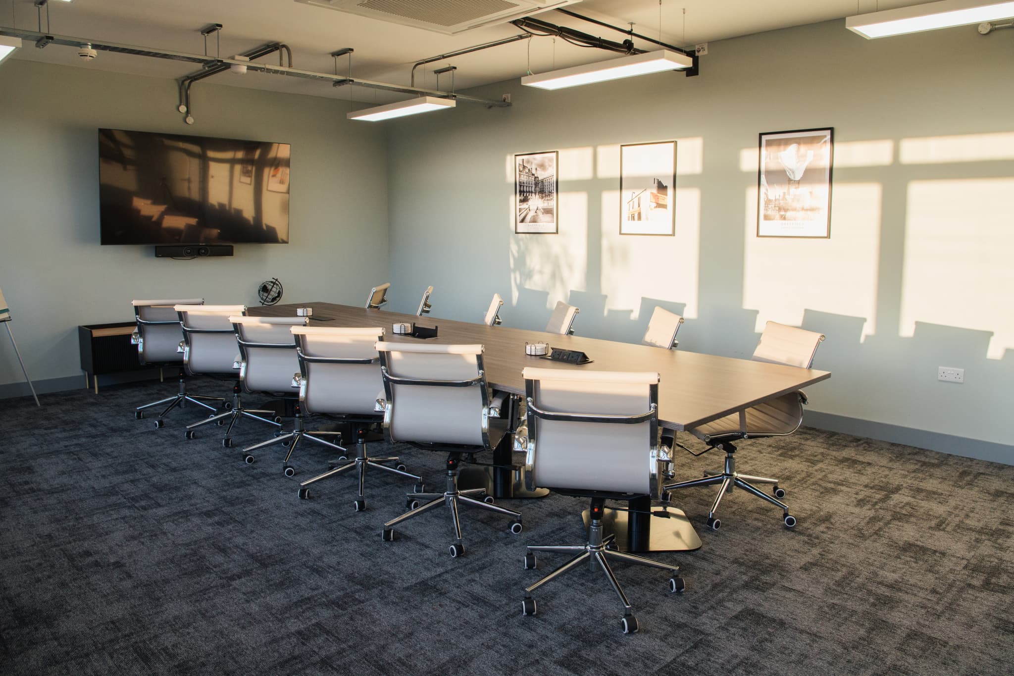 Modern boardroom in Wizu Workspace featuring ergonomic chairs for professional hybrid meetings.