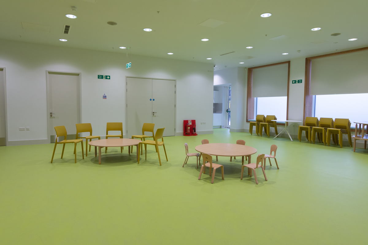 Versatile meeting space with round tables and colorful chairs for workshops at Una Marson Library.