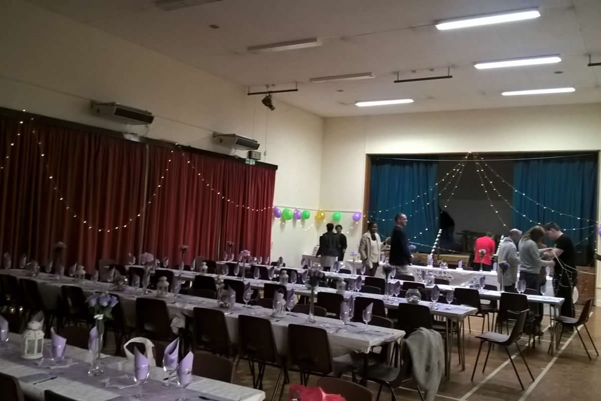 Arkley Village Hall event space with tables, string lights, and balloons for gatherings.