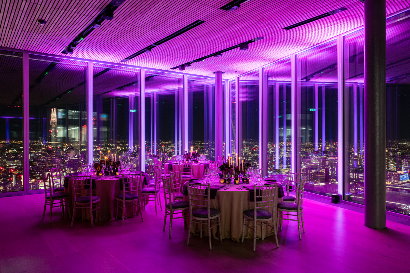Elegant event space at The Lookout, featuring round tables and city skyline views.