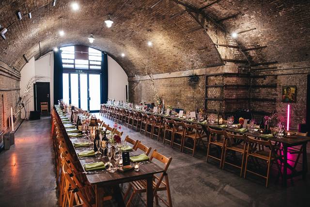 Elegant wedding venue with arched brick room and stylish dining table for intimate gatherings.