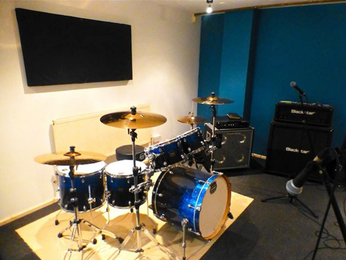Recording studio in K-Town with drum set, ideal for music workshops and band rehearsals.