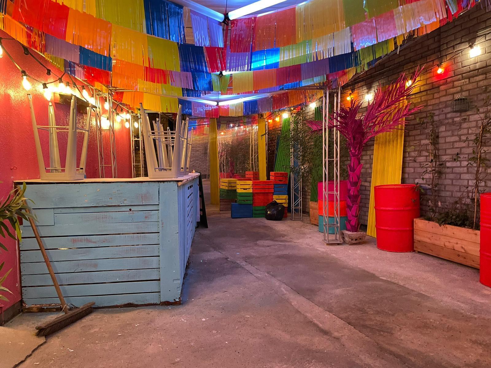 Vibrant enclosed backyard event space in Hoxton Arches with colorful decor and lighting.