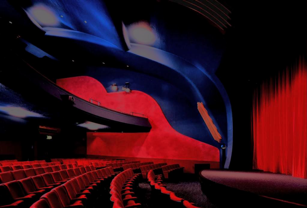 Vibrant theater with red curtain, ideal for performances and corporate events.