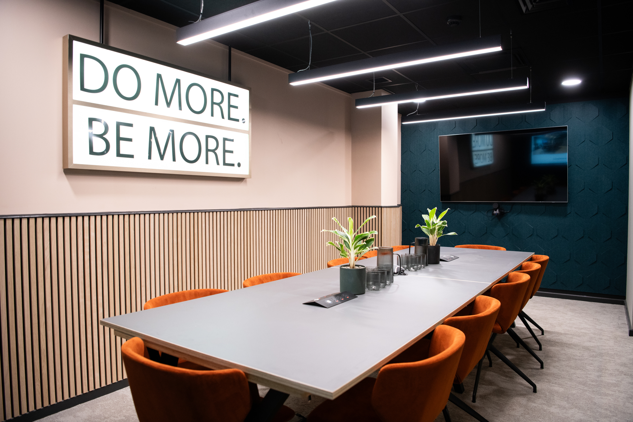 Modern meeting room in Wizu Workspace with vibrant orange chairs for collaborative events.