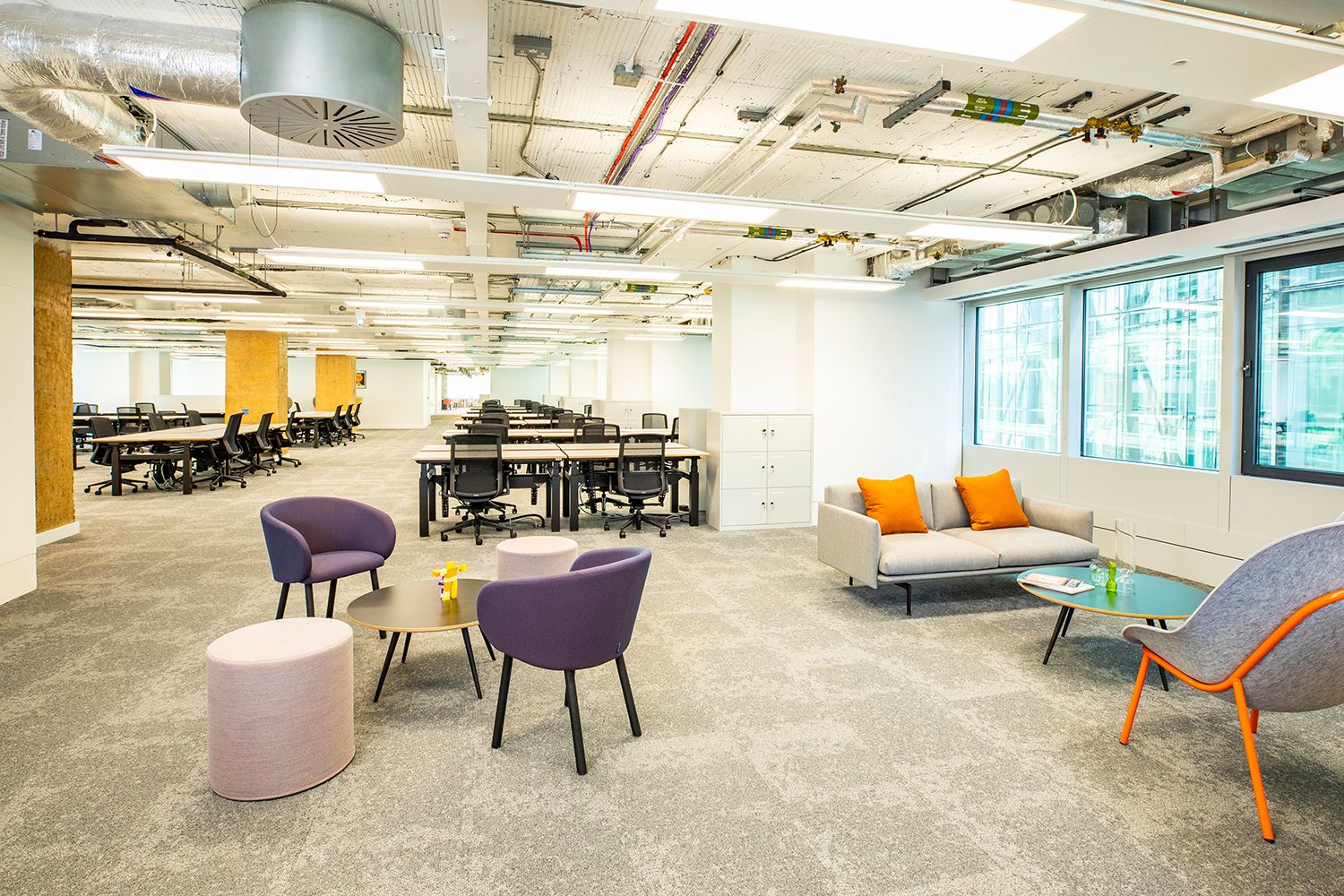 Modern corporate office workspace with colorful seating for events and collaboration.